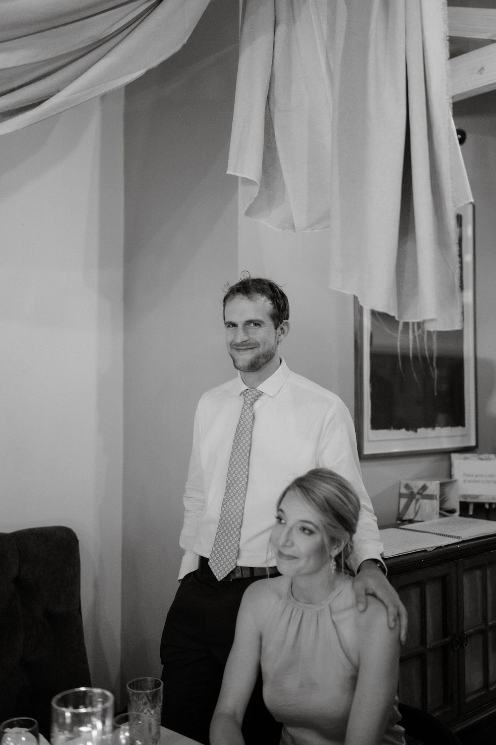 Black and white portrait of a couple at an elegant indoor reception.