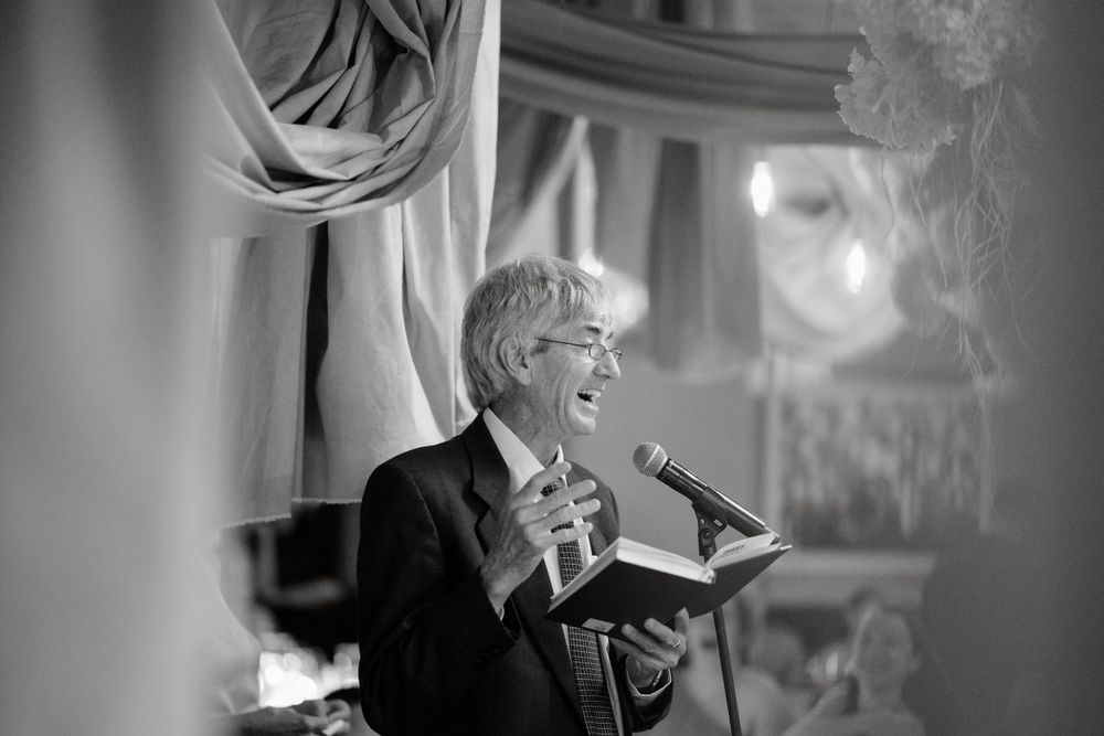 Black and white photograph of someone speaking passionately at a formal event.