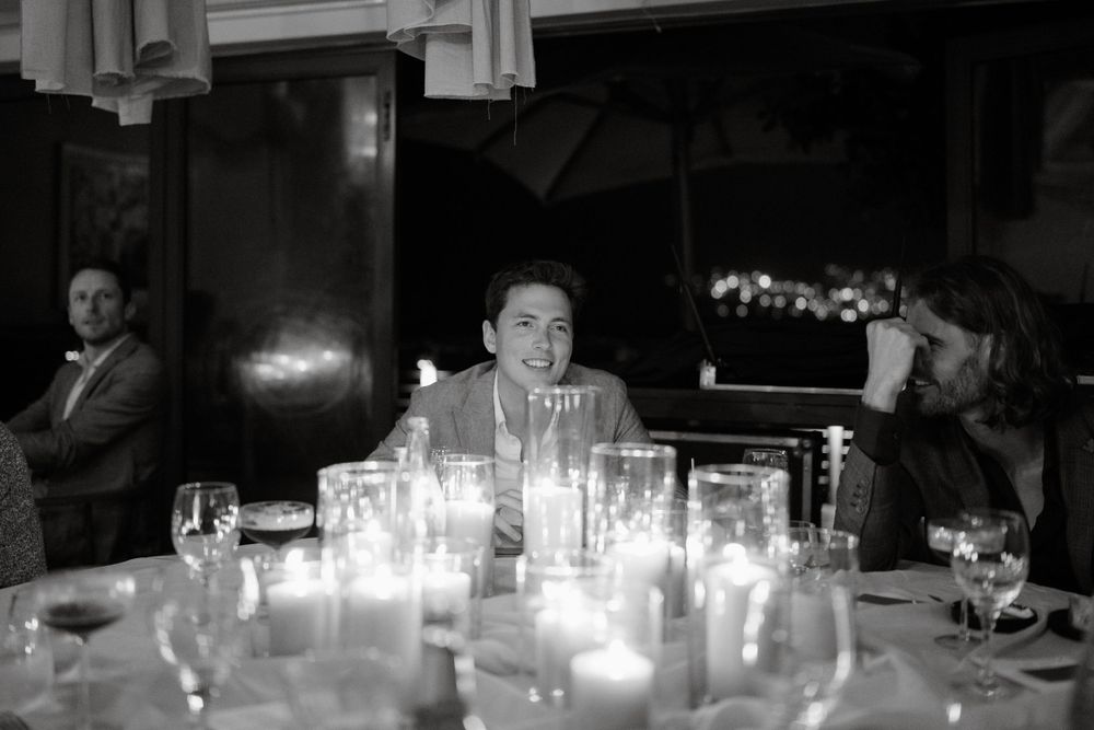 Black and white candlelit reception photo with glowing table settings.