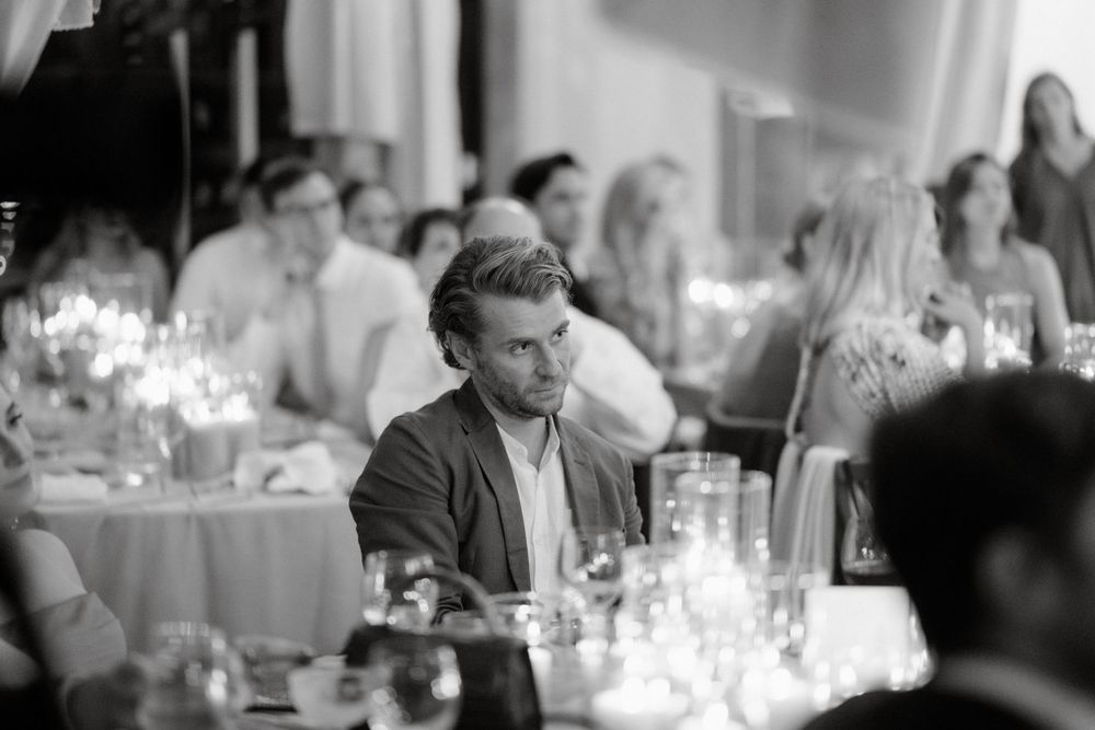 Guest sits at candlelit wedding reception table in black and white.