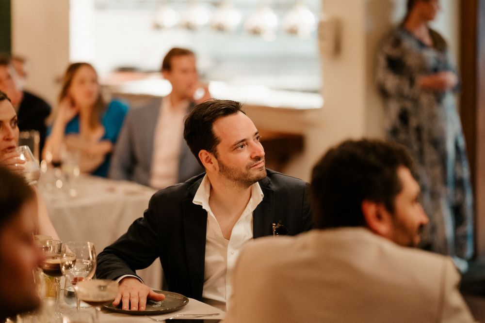 Reception guests seated at dining tables during an elegant indoor wedding celebration.