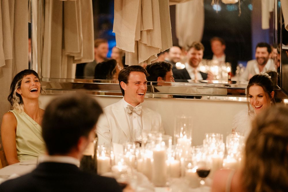 Wedding reception guests enjoying a candlelit dinner celebration.
