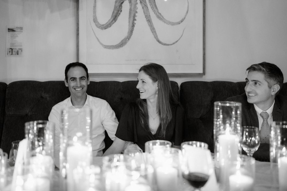 Black and white candid reception photo with candlelit table settings.