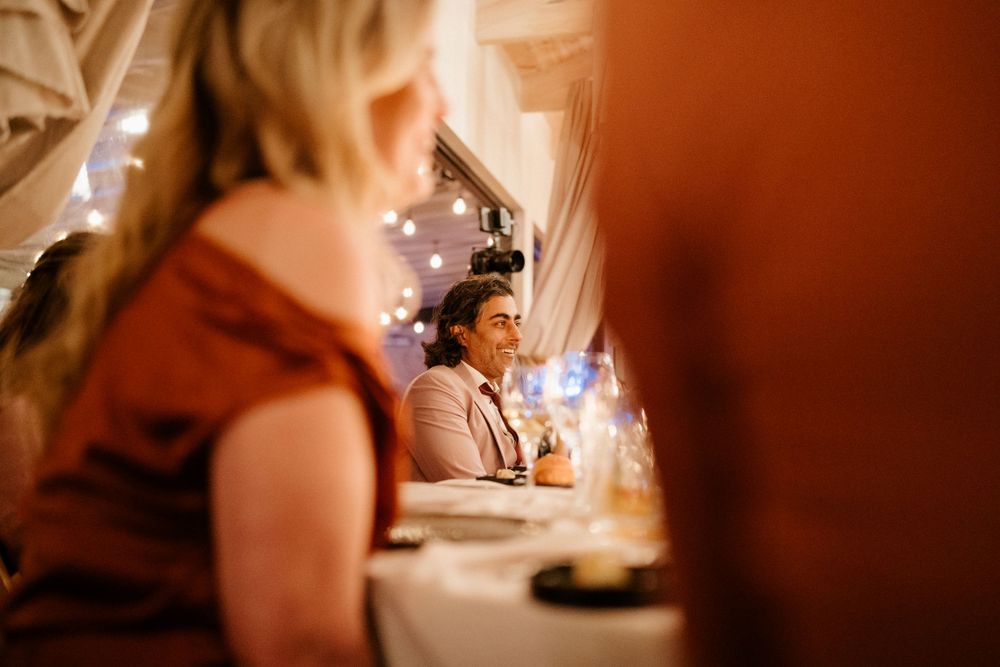 Candlelit wedding reception dinner with twinkle lights creating an intimate warm atmosphere.