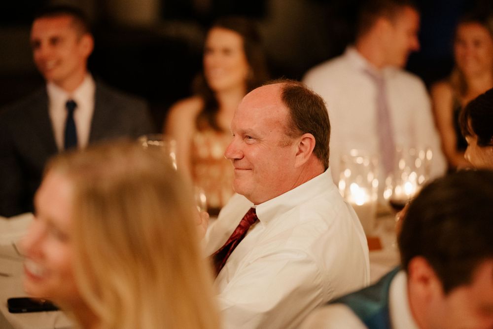 Guest enjoying wedding reception dinner in dimly lit venue.