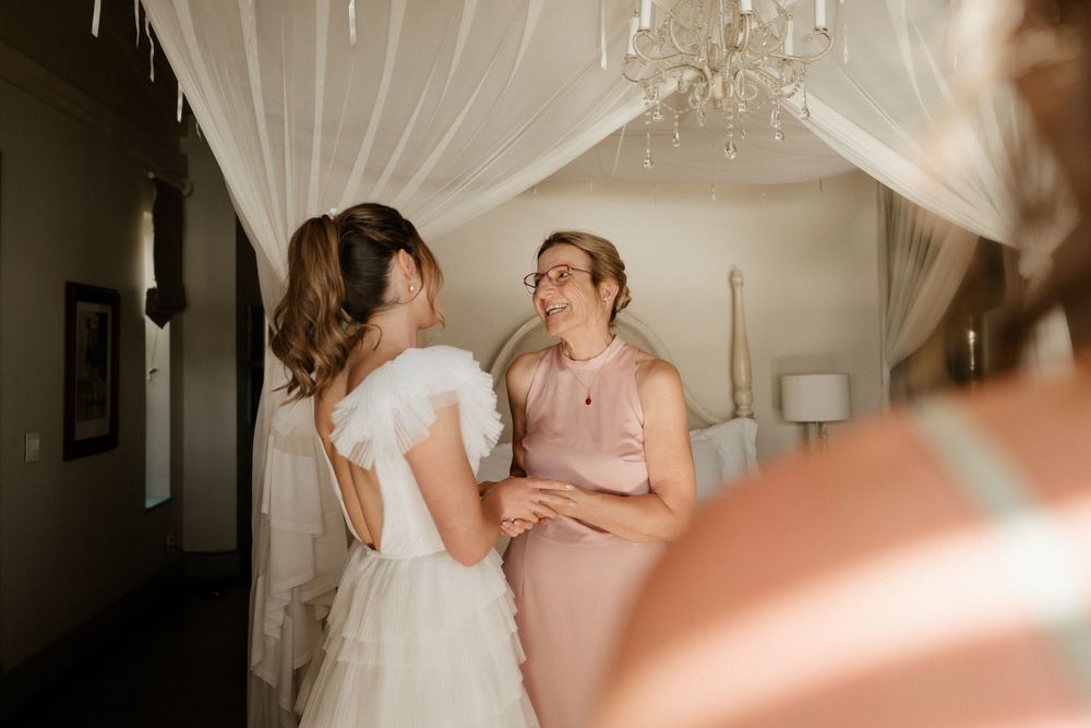 Intimate getting ready moment in bridal suite with soft natural lighting.