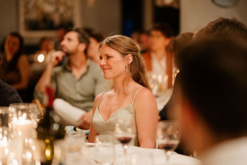 Candlelit wedding reception scene with elegant table settings and soft ambient lighting.