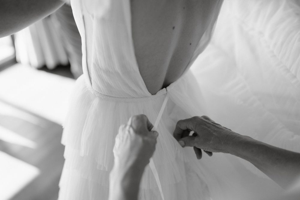 Close-up of hands adjusting white fabric in black and white.