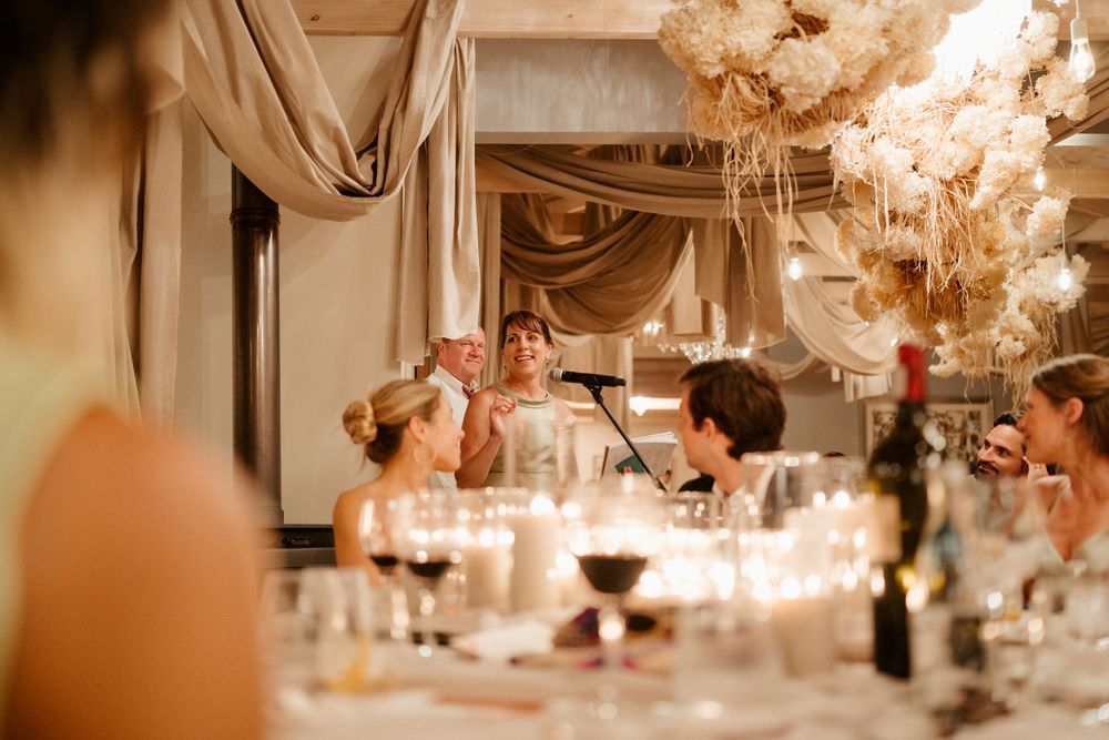 Romantic wedding reception dinner table with candlelight and elegant draping decor.