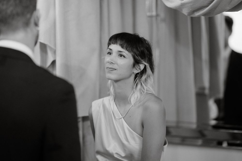 A guest in a one-shoulder dress attends an elegant indoor wedding reception.