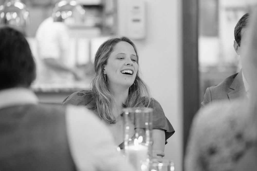A candid black and white moment captured during a lively reception celebration.