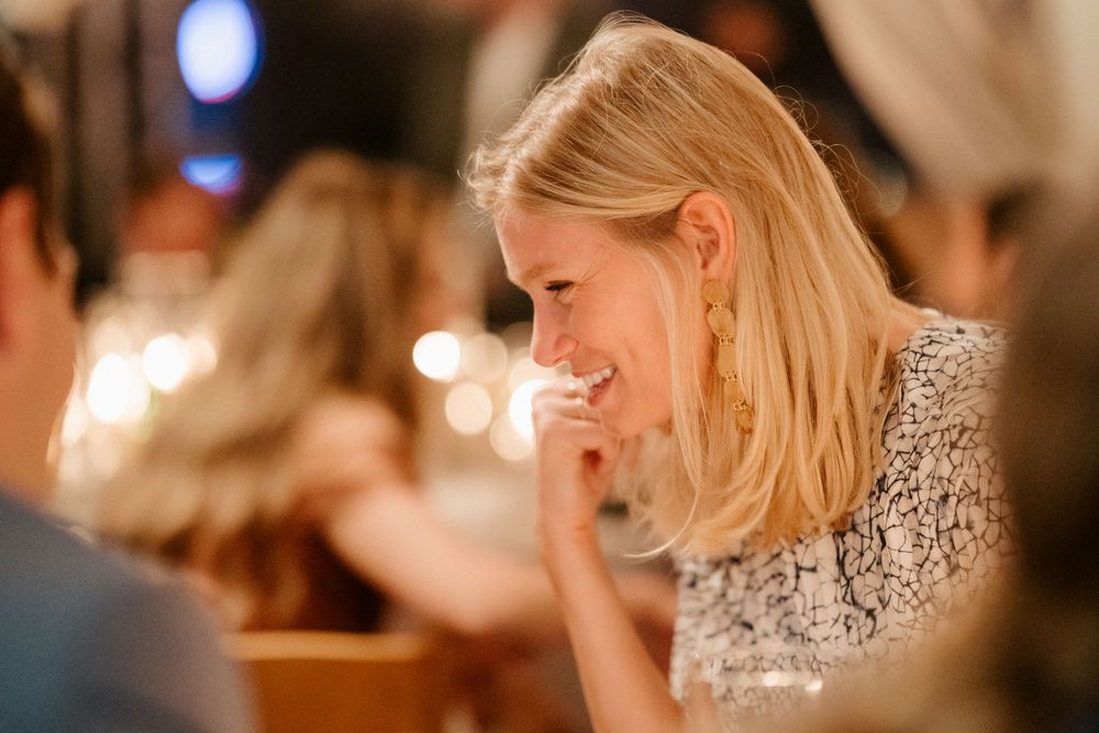Woman in sparkly dress laughing during a festive evening celebration.