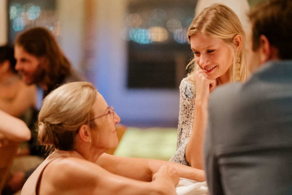People engaged in an intimate conversation at an elegant reception.