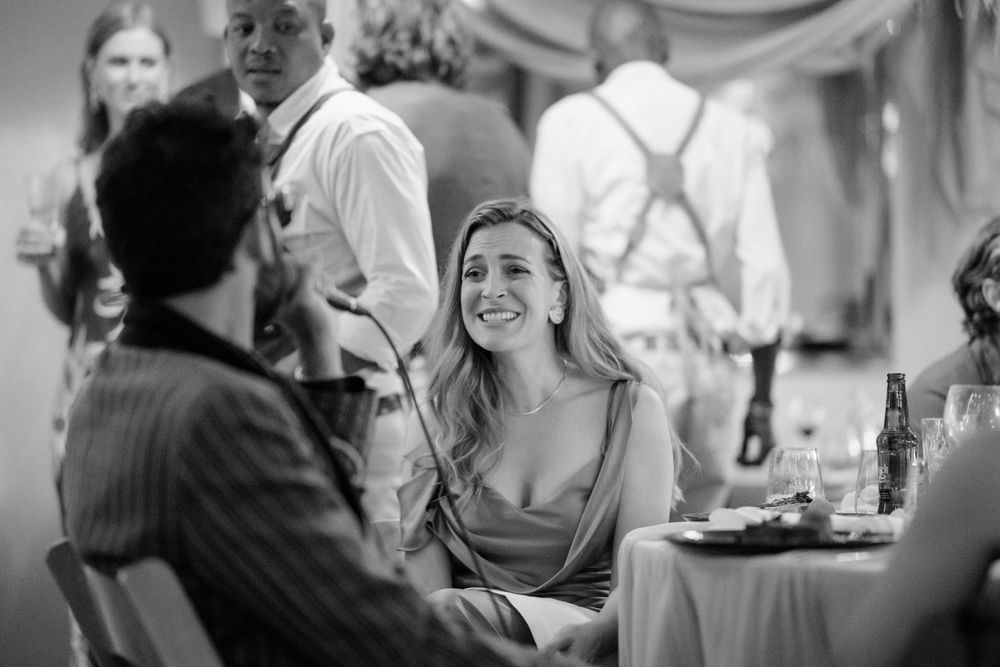 Wedding guests engage in lively conversation during an elegant indoor reception.