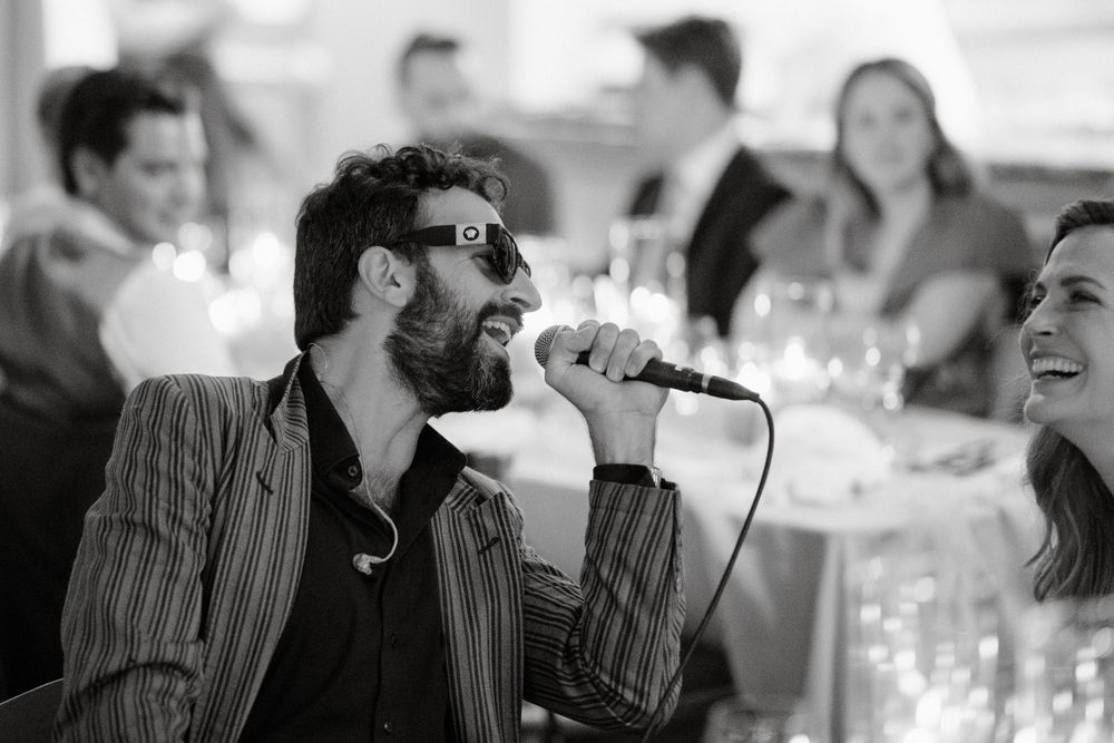 Wedding singer performing with microphone during reception entertainment.