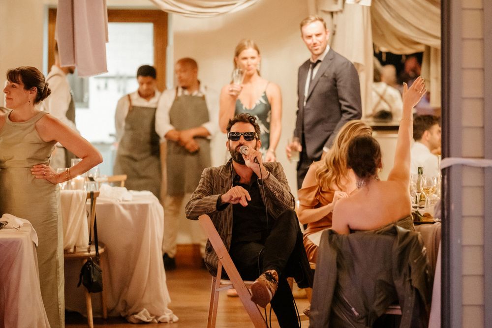 Wedding reception scene with venue staff and guests mingling in an elegantly decorated space.