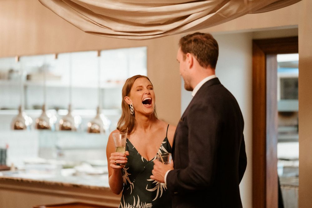 Candid moment of laughter between two people during an evening celebration.