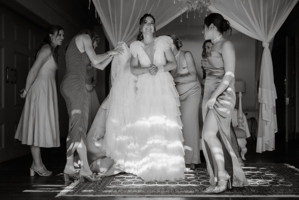 Black and white photograph showing preparations in a room with flowing white curtains.