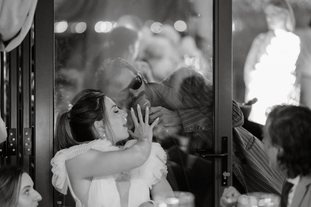Black and white photo captures emotional celebration during wedding reception.