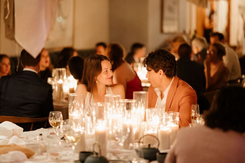 Intimate candlelit dinner conversation at an elegant wedding reception.