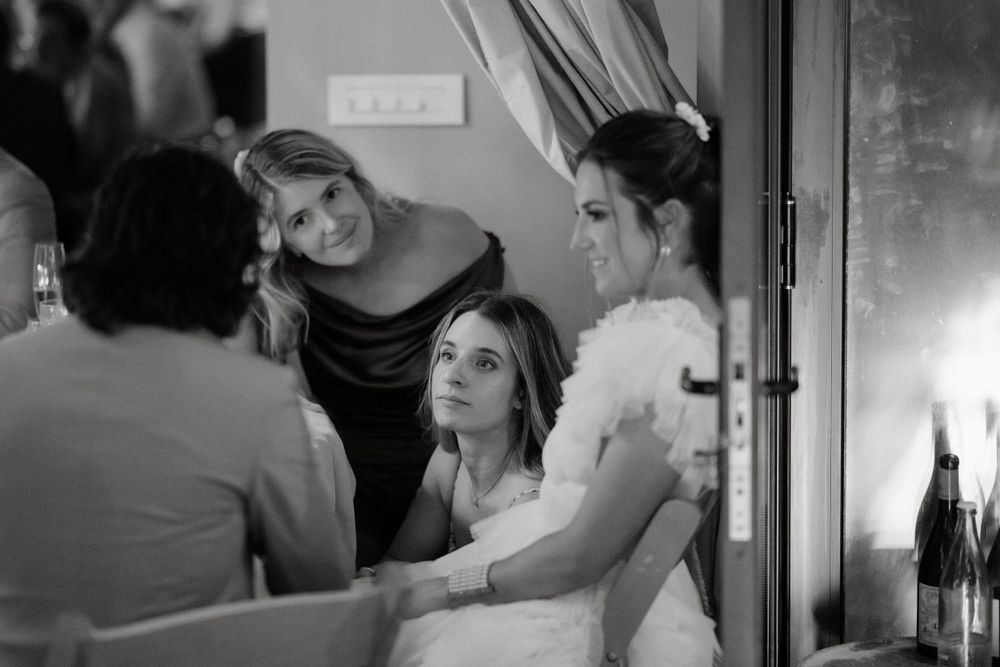 Intimate gathering of people having a conversation in a dimly lit setting.