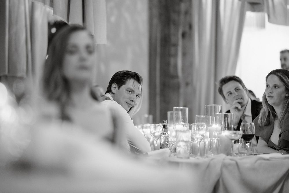 Black and white candlelit reception dinner with guests at elegant table settings.