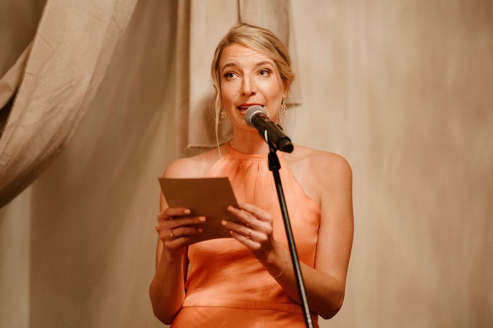 Wedding speech being delivered at an elegant reception with draped decor.