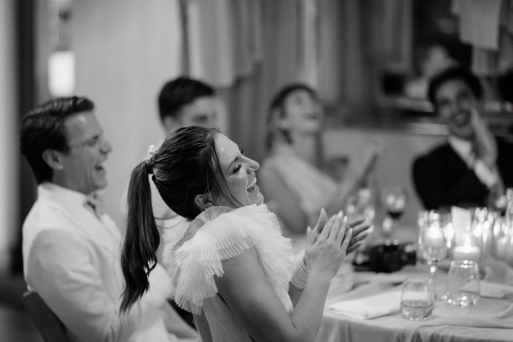 Black and white capture of joyful wedding reception reactions.