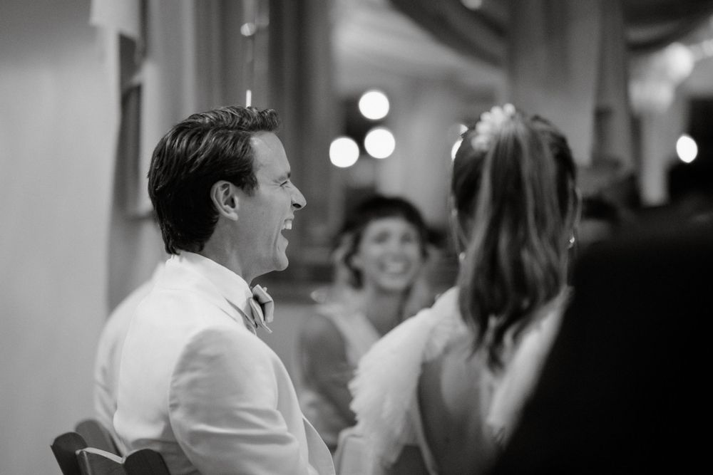 Black and white candid shot of guests mingling at an evening celebration.
