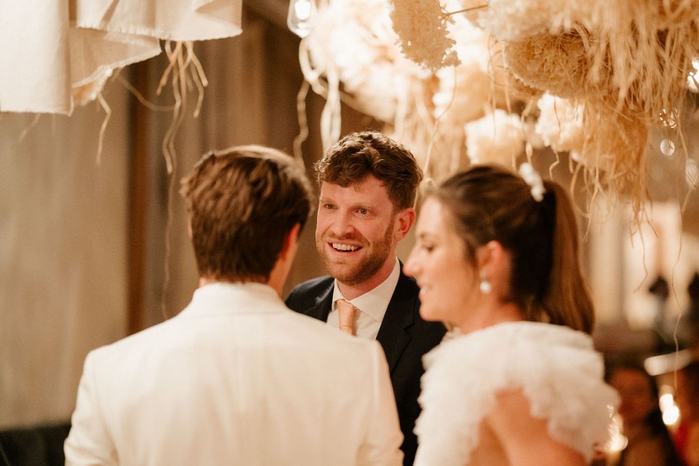 Wedding celebration conversation captured in warm tones with decorative lighting.
