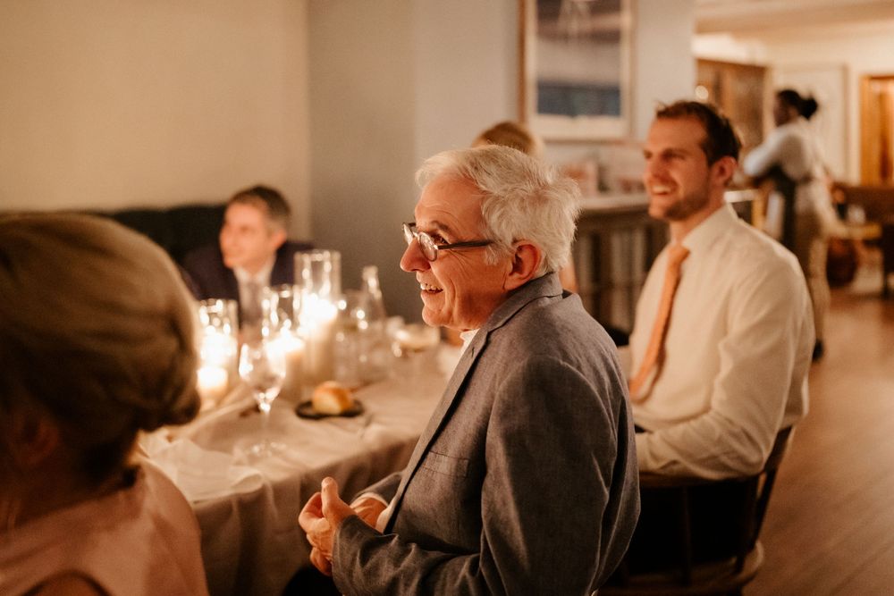 Elegant dinner reception scene with guests dining by warm candlelight.