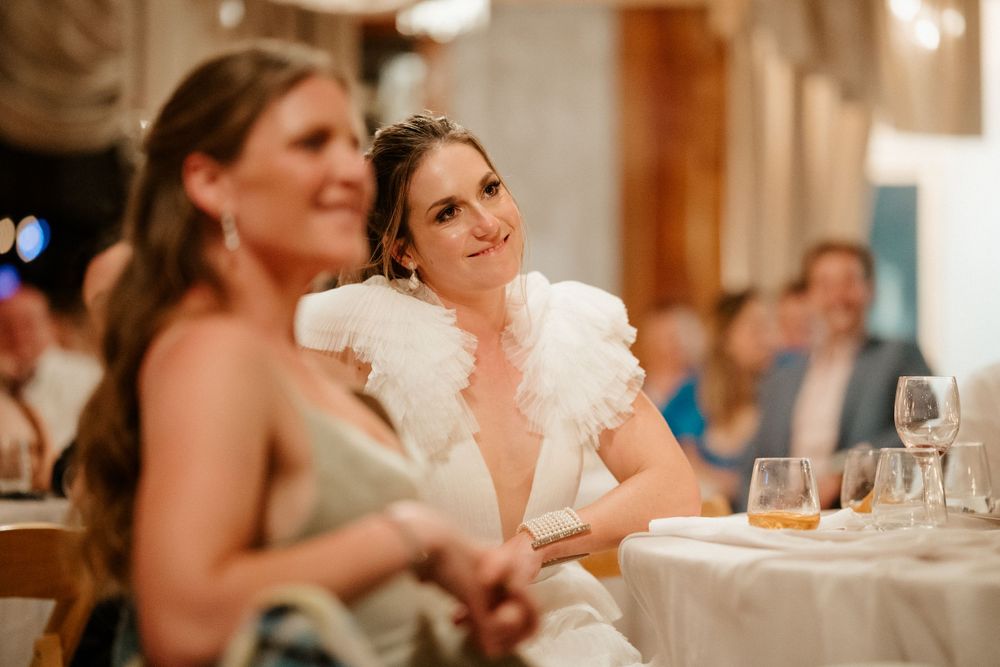 Elegant wedding guests enjoy conversation during formal reception dinner.