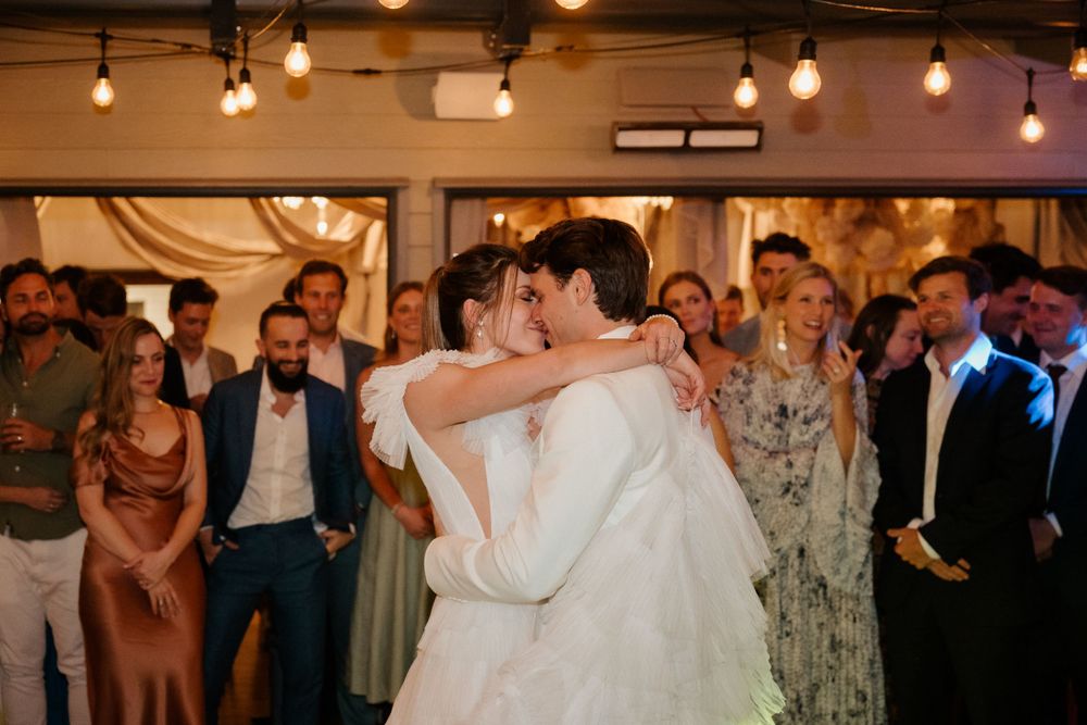 Couple shares their first dance surrounded by guests at a romantic wedding reception.
