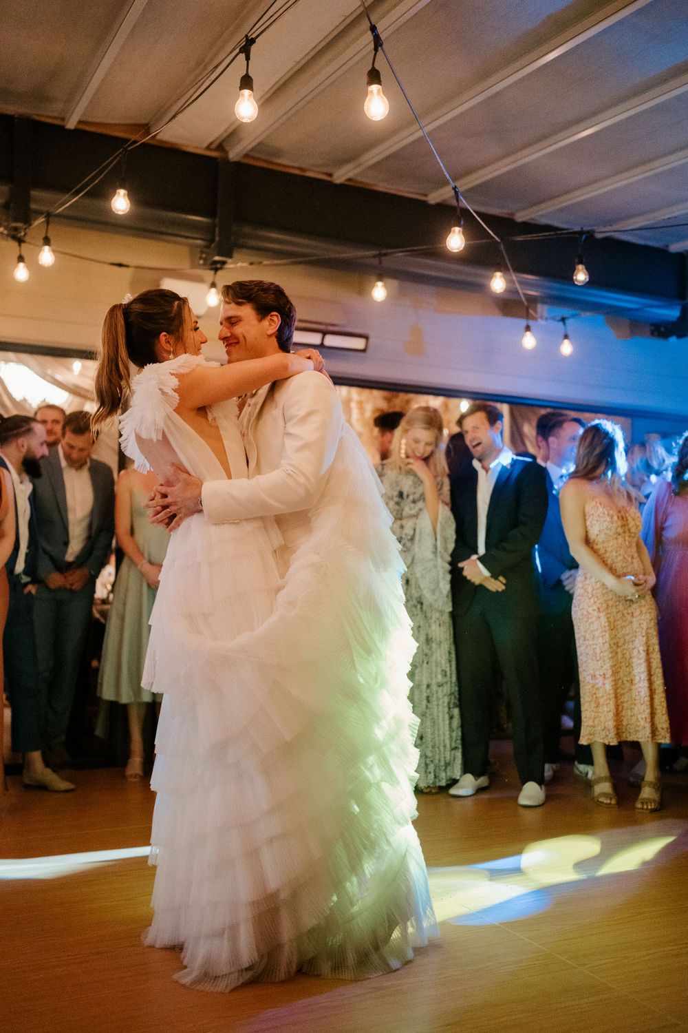 Romantic first dance of newlyweds under soft lighting at their wedding reception.