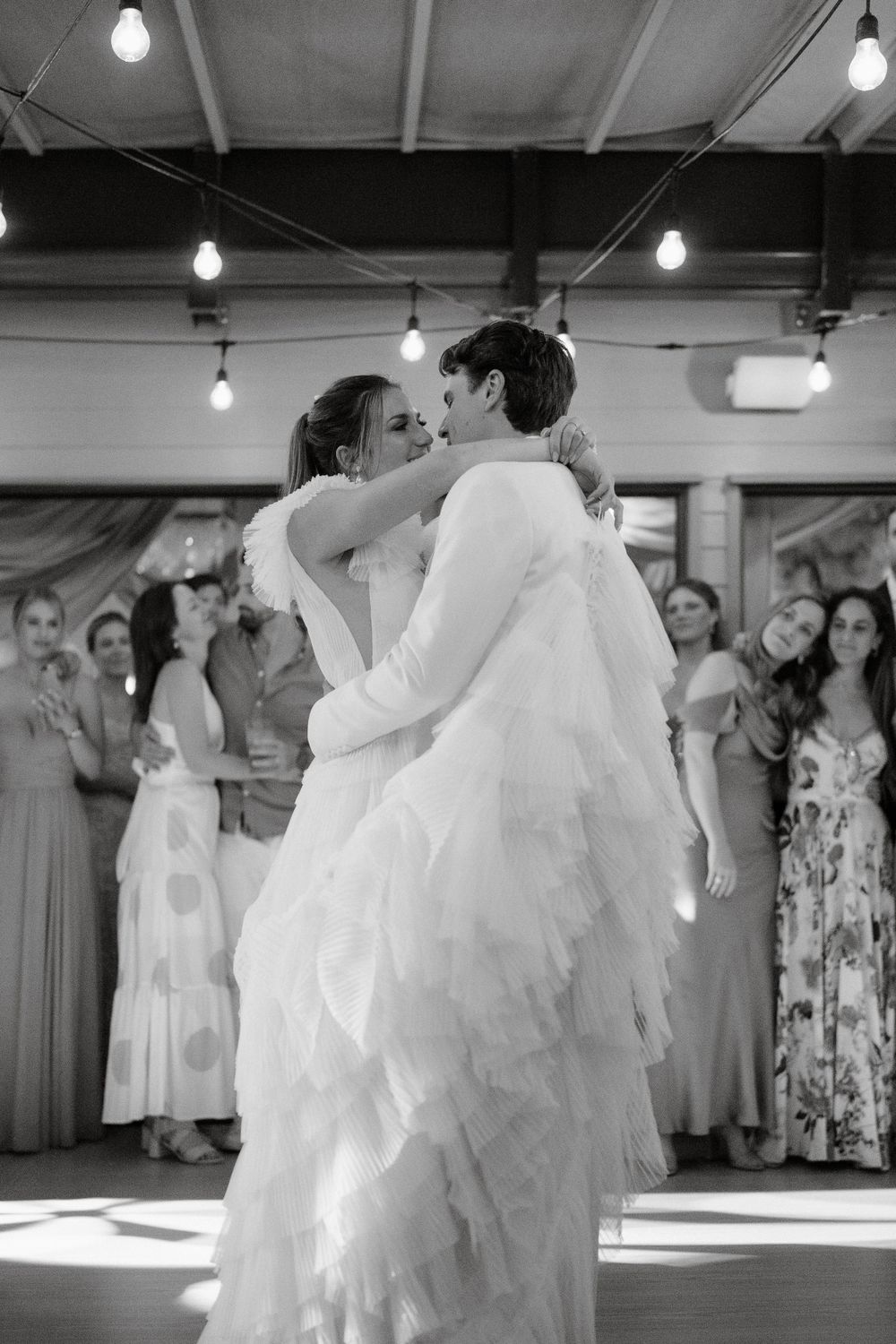 Black and white photo captures an intimate first dance moment at a wedding reception.