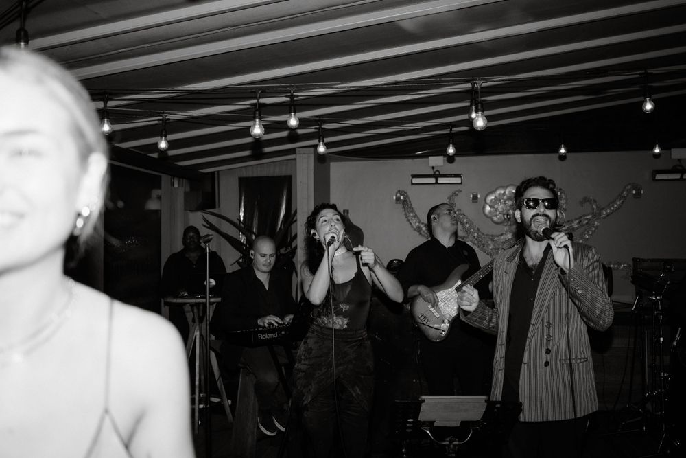 Live band performing on stage at a dimly lit indoor venue.