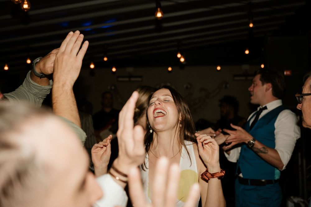 Joyful celebration with hands raised high during an energetic dance party moment.
