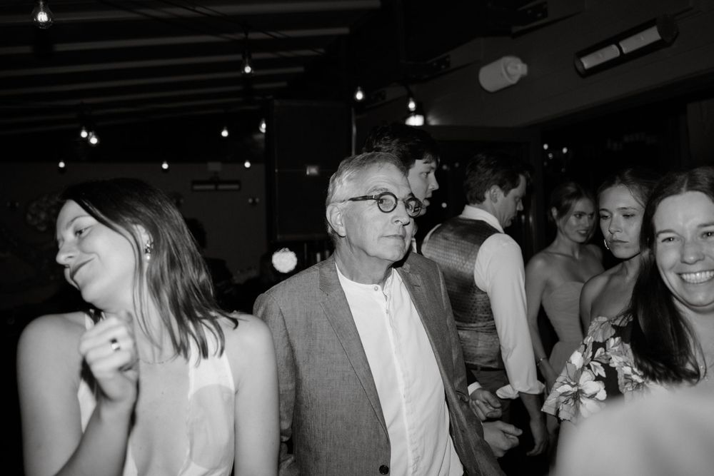 Black and white photo of guests enjoying themselves on a lively dance floor.