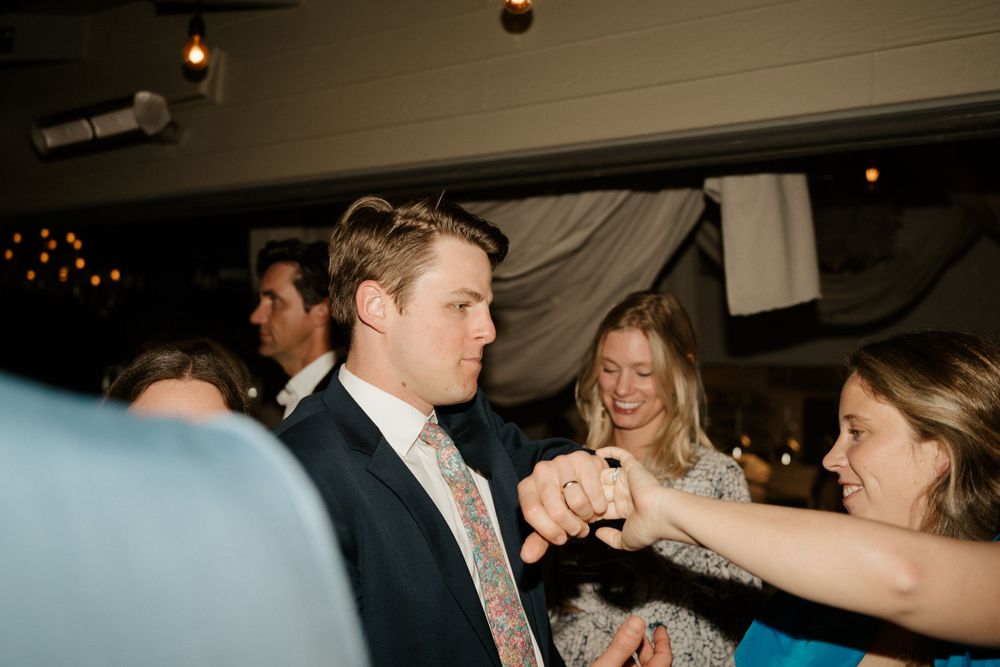 Wedding guests sharing a celebratory moment during a lively indoor reception.