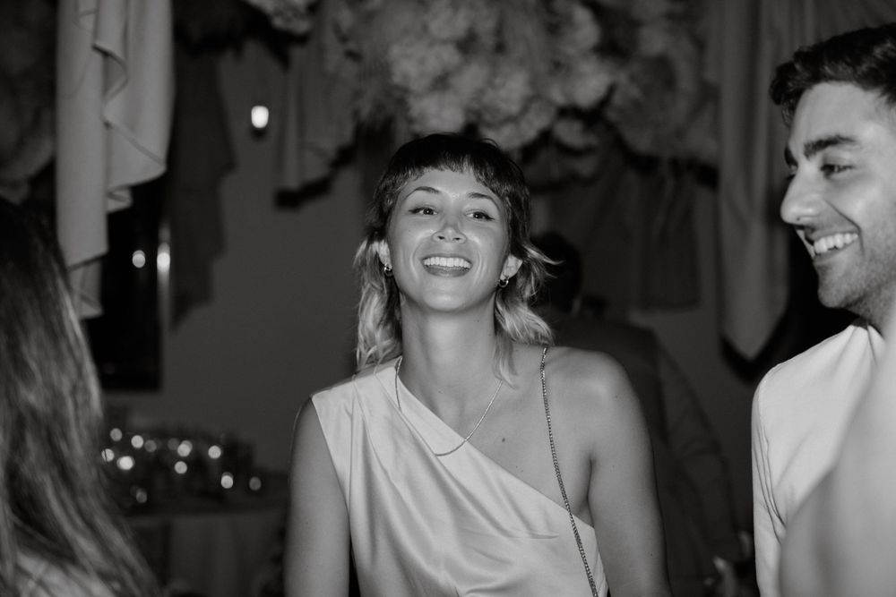 Black and white candid party photo showing people laughing and enjoying themselves.