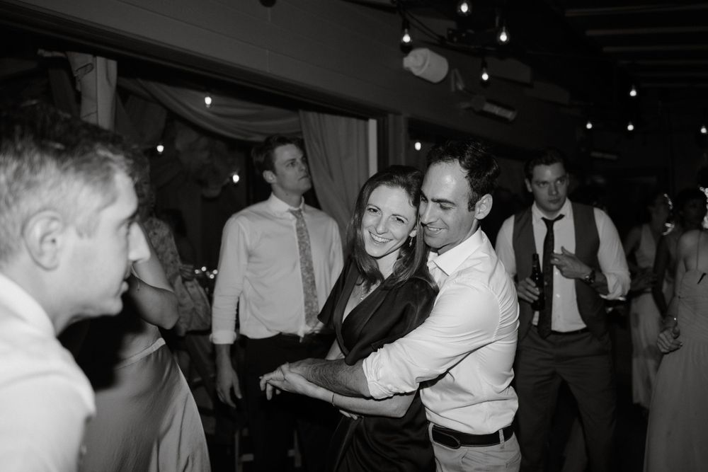 Dance floor moment captured in black and white at a wedding reception celebration.