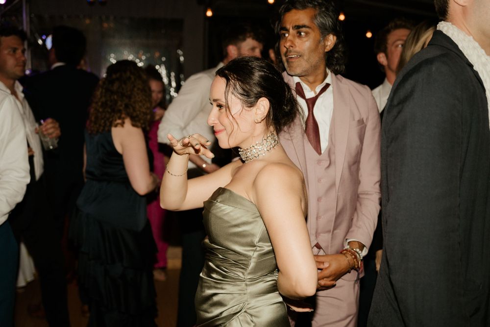 Wedding reception guests dancing and celebrating on the dance floor.