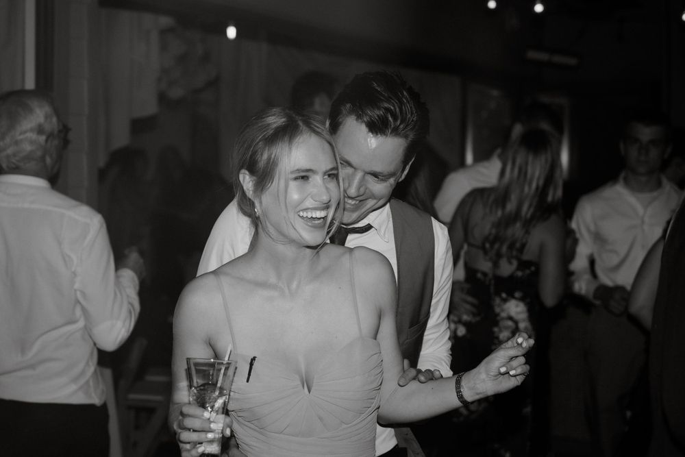 A black and white photo of a couple dancing intimately at their wedding reception.