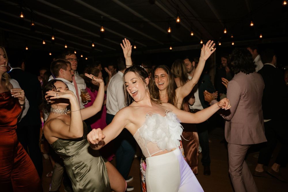 Lively wedding reception dance floor with celebratory party atmosphere.