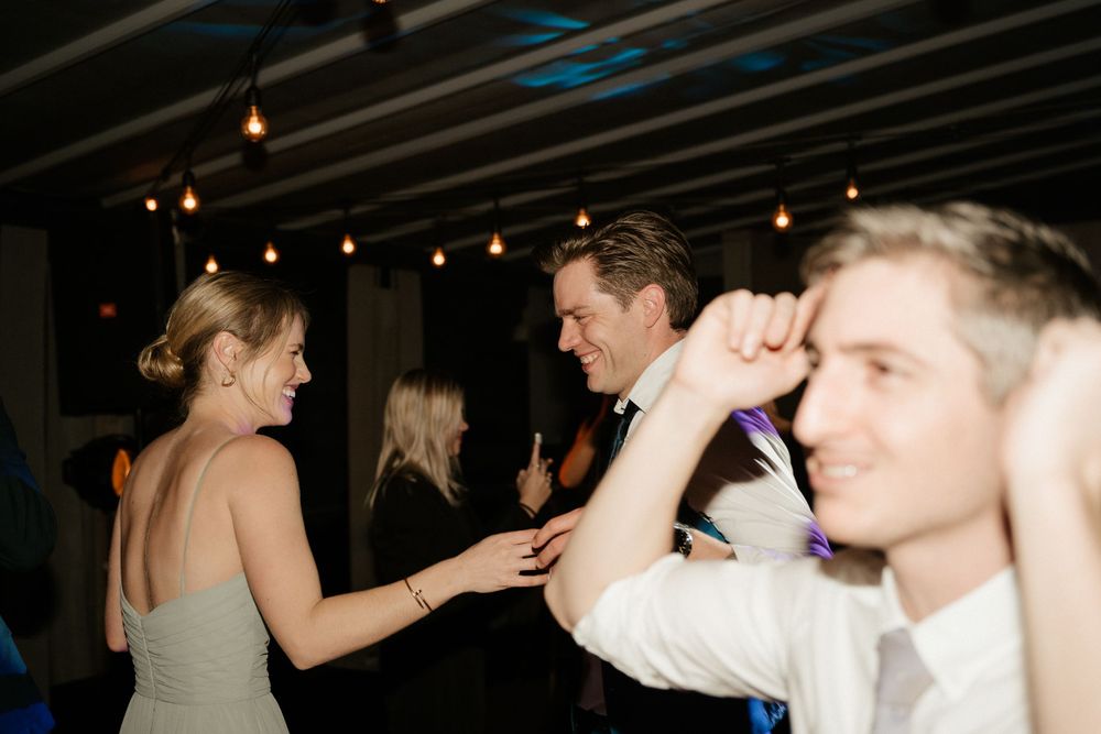 Lively dance party scene with string lights illuminating a dark venue.