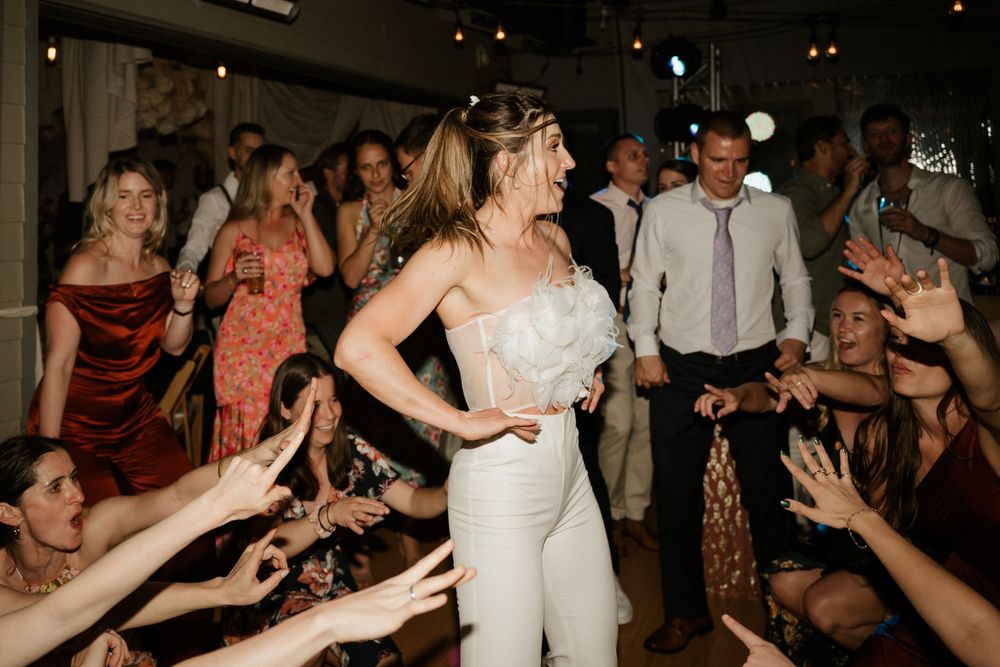 Energetic dance party scene with guests celebrating at a wedding reception.