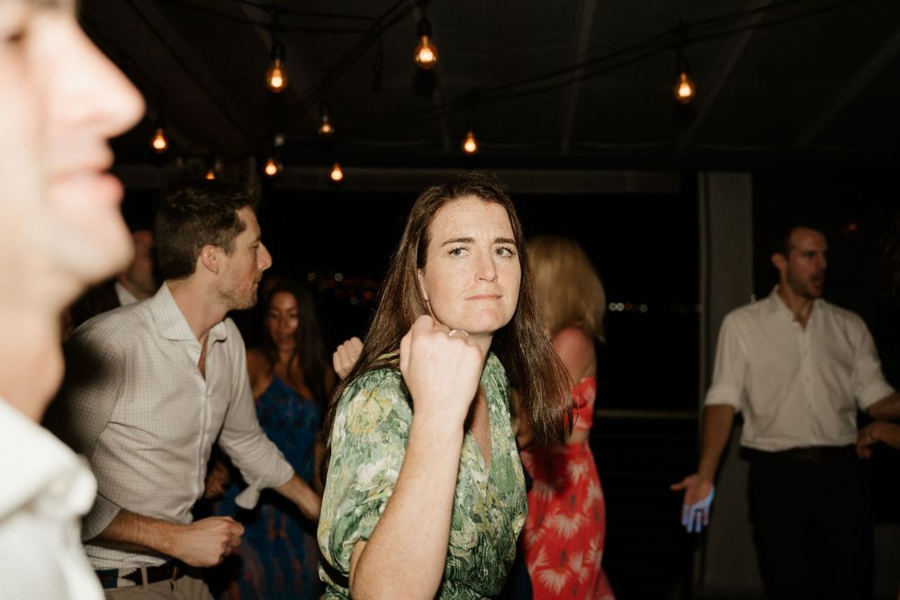 Guests dancing and socializing at a dimly lit evening reception.