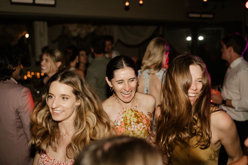 Wedding guests enjoying themselves and laughing at a lively reception party.