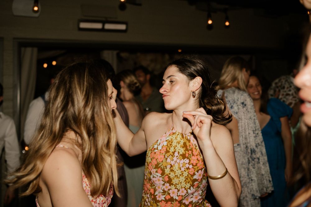 Wedding guests dancing and celebrating at an evening reception party.