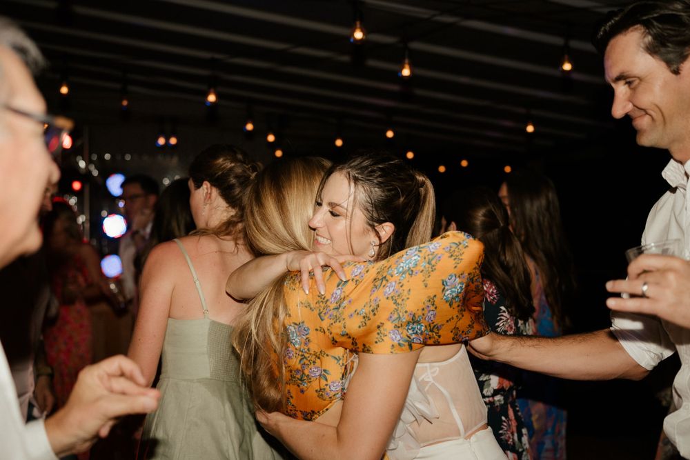 Wedding reception dance floor moment with guests in colorful attire.